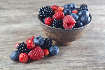 Assorted berries in bowl on wood