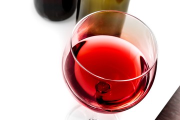 top of view of red wine glass near wine bottles