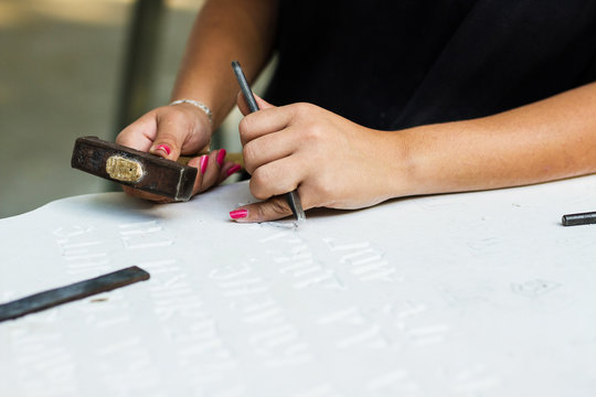 Young woman carving stone statue