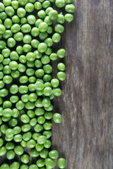 Pod of green peas on wood