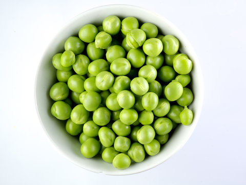 Green peas in the bowl isolated on white 