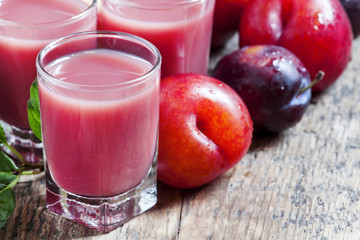 Delicious fresh juice of red and blue sweet plums and peach in a