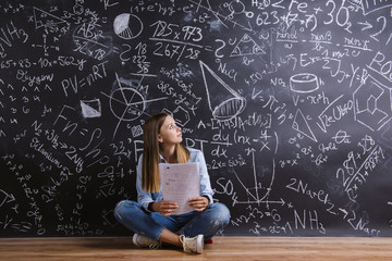 Beautiful young girl in front of blackboard