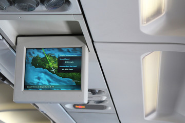 Monitor near window in passenger plane, showing destination