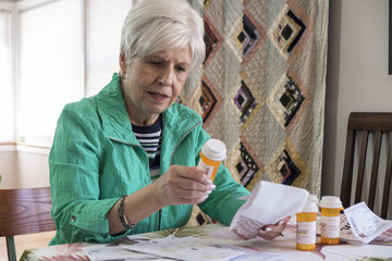 A mature woman looking over medical bills