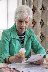 A mature woman looking over medical bills