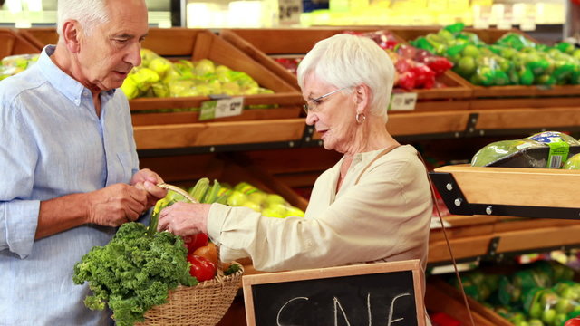 Senior couple picking out vegetables in supermarket