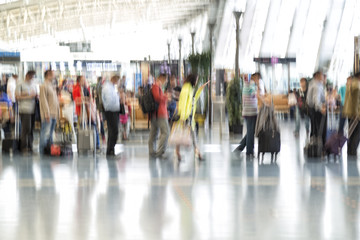 People silhouettes in motion blur, airport interior