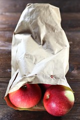 Äpfel der Sorte Elstar in Papiertüte auf Holzhintergrund