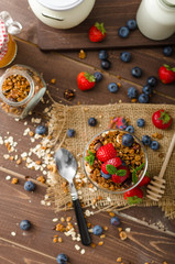 Obraz na płótnie Canvas Yogurt with baked granola and berries in small glass
