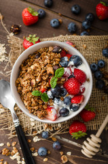 Yogurt with baked granola and berries in small bowl