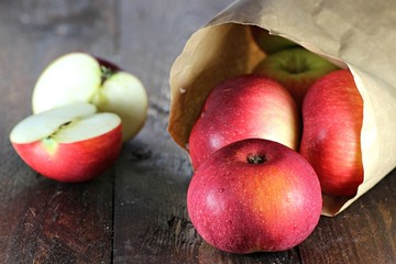 Äpfel der Sorte Elstar in Papiertüte auf Holzhintergrund