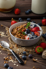 Yogurt with baked granola and berries in small bowl