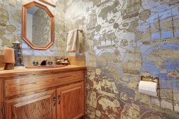 Unique half bathroom with sailor wall paper.
