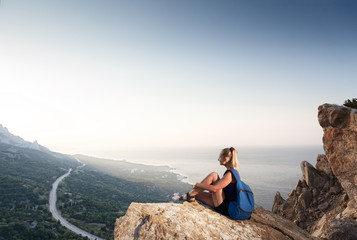 Woman looks at sunrise on the mountain
