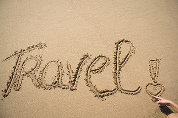 The word travel written in the sand on a beach in Mozambique
