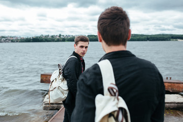 two young guys standing on a pier