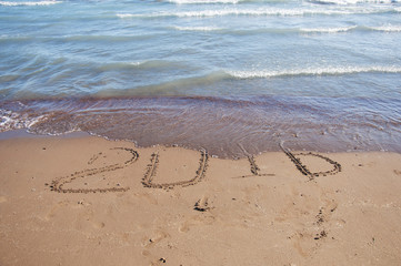 2016 written in sand on sunny beach
