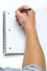 Man's hand drawing in a notebook