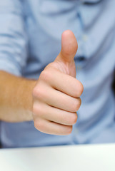 man in office showing thumbs up