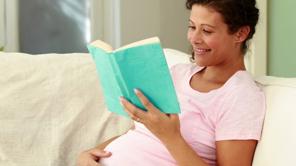 Pregnant woman reading on the couch