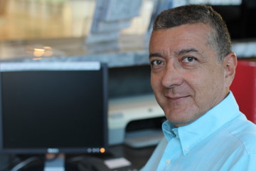 Elder Man Working At Desk In Busy Creative Office