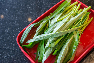water spinach on red plate