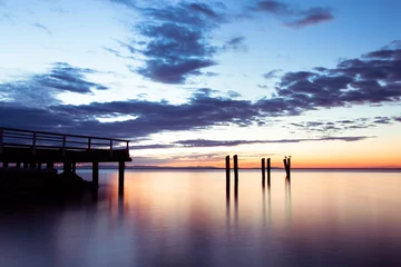 Photo sur Plexiglas Jetée sunset pier with clouds and soft water
