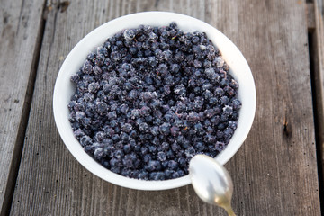 Full plate of blueberries on old wooden table