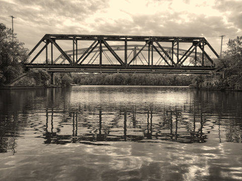 Fototapeta Monochrome Railroad Bridge Over a River with Reflections