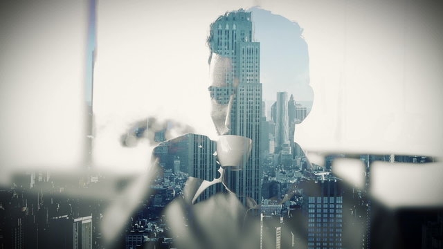 Cityscape overlay on businessman drinking coffee