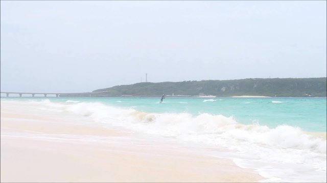 悪天候の与那覇前浜ビーチでカイトサーフィンをする人々