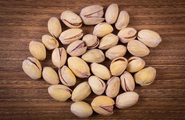 Vintage photo of pistachio nuts on wooden table, healthy eating