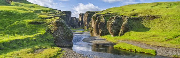 Fototapeten grüne Hügel der Schlucht mit Fluss und Himmel in Island © sergejson