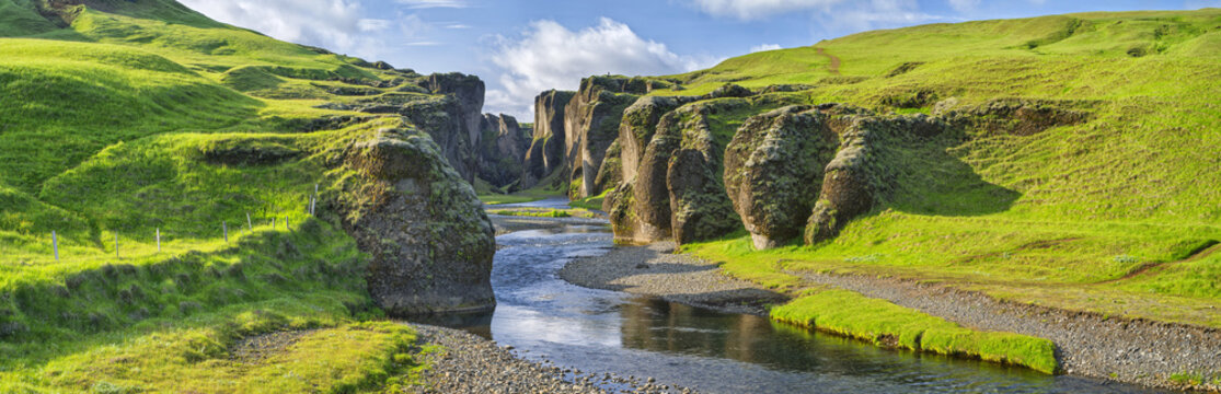 green hills of canyon with river and sky in Iceland