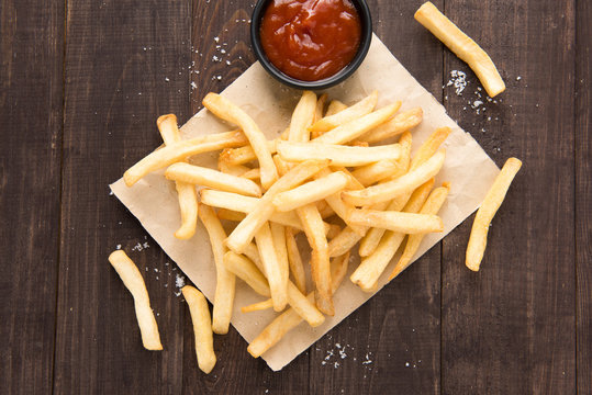 French fries with ketchup on wooden background