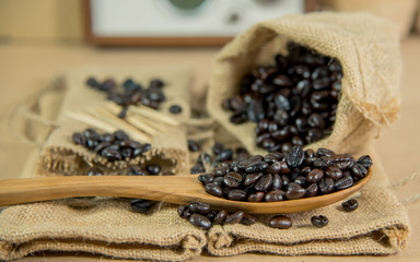 Fototapeta na wymiar Vintage photo of Coffee beans and wooden spoon on sack surface,