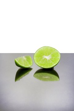 Lime slices on the mirror table and white background.