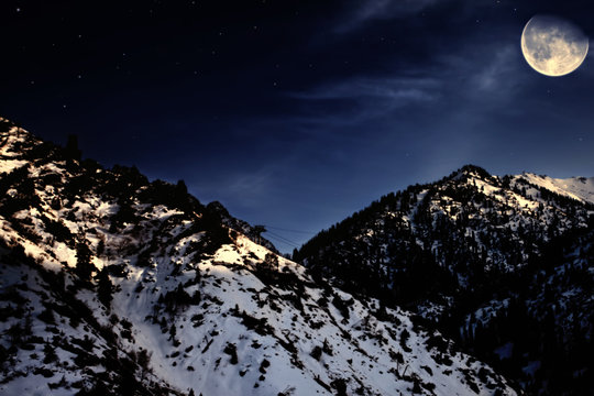 mountain winter landscape with yellow moon