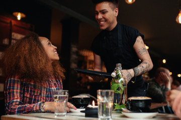 Woman talking to waiter at cafe