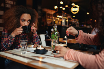 Young woman drinking coffee at cafe