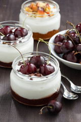 dessert with cream and jam in glass jar on wooden table