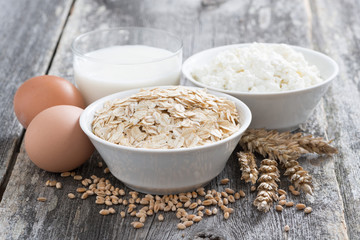 oatmeal, eggs, cottage cheese and milk on wooden background