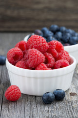 seasonal berries - raspberries and blueberries in bowls