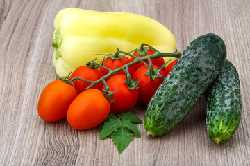 Cucumbers and tomatoes on the branch with yellow pepper