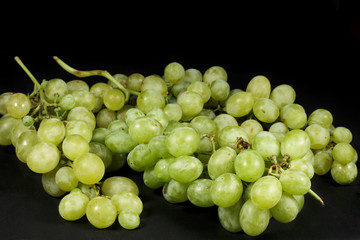 Several bunches of table grapes isolated on black background