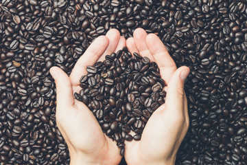 Pair of hands holding coffee beans