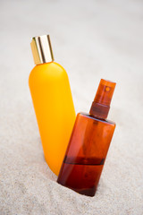 sunbathing concept -suntan lotion bottles in sand