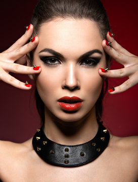 Beautiful woman in gothic style, evening makeup and red nails with thorns.