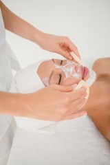 Hand cleaning womans face with cotton swabs